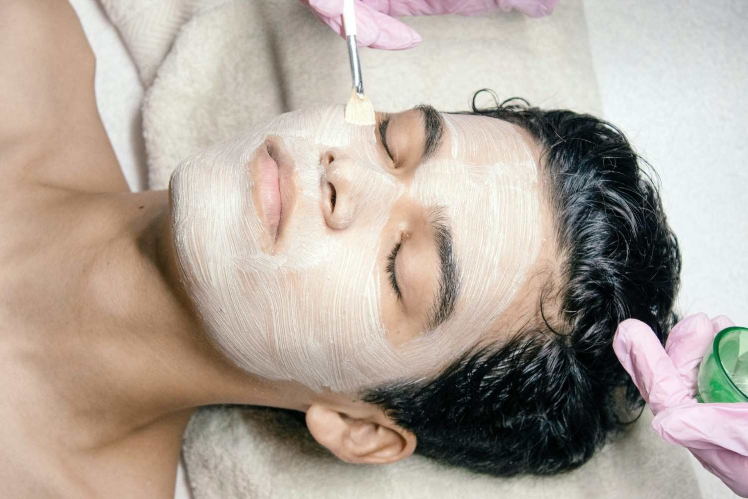 A man getting a facial mask on his face